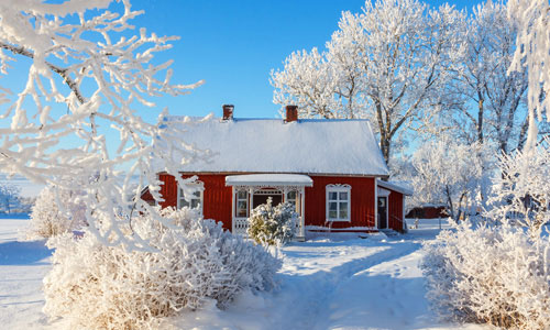 Snow-covered red cottage